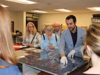 group of people looking at an archival document
