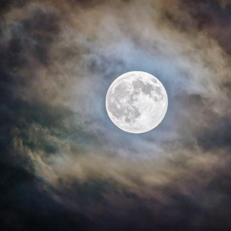 Full moon in a cloudy night sky.